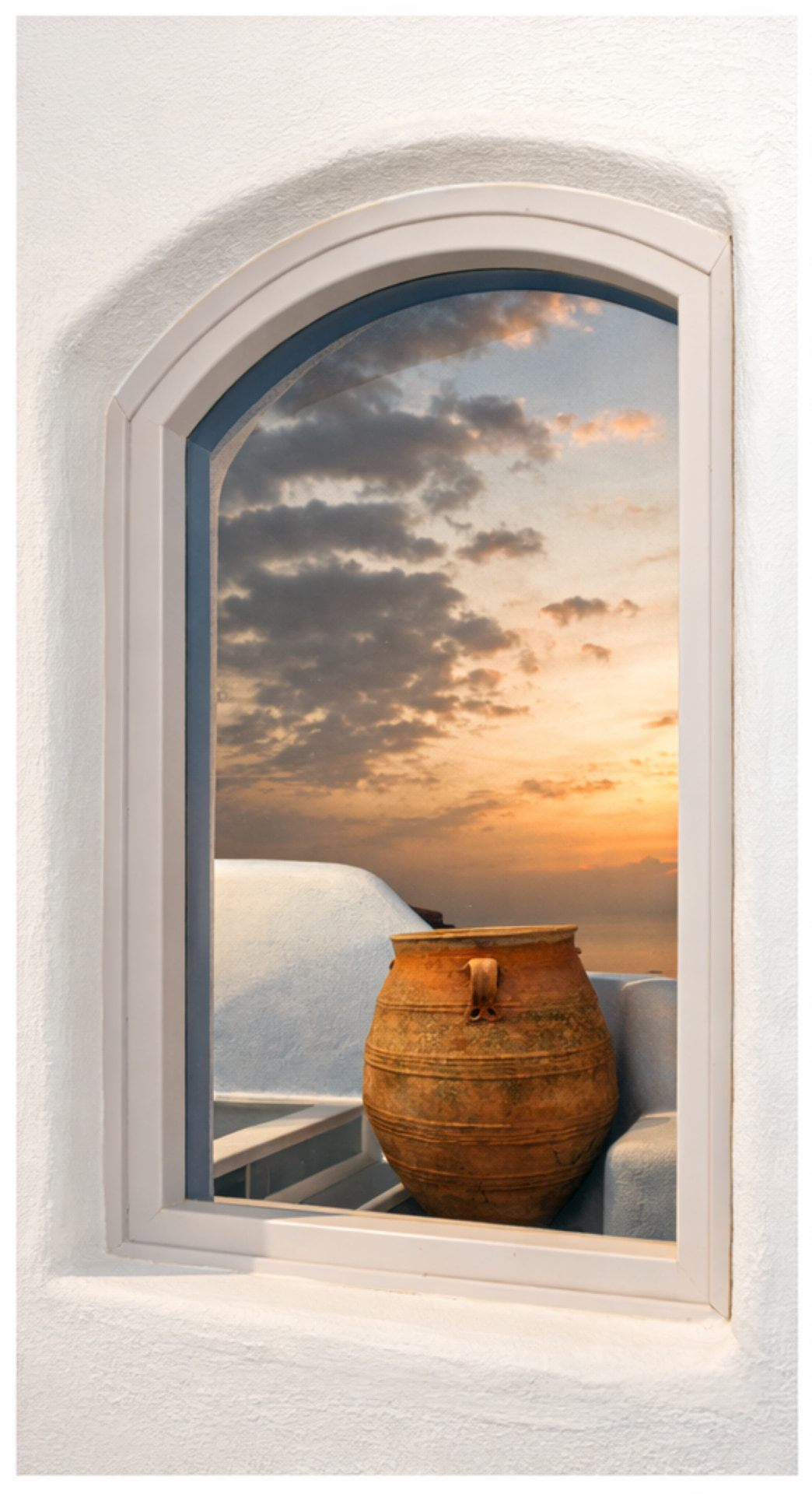 Sunset framed through Cycladic window at Ikastikies Suites