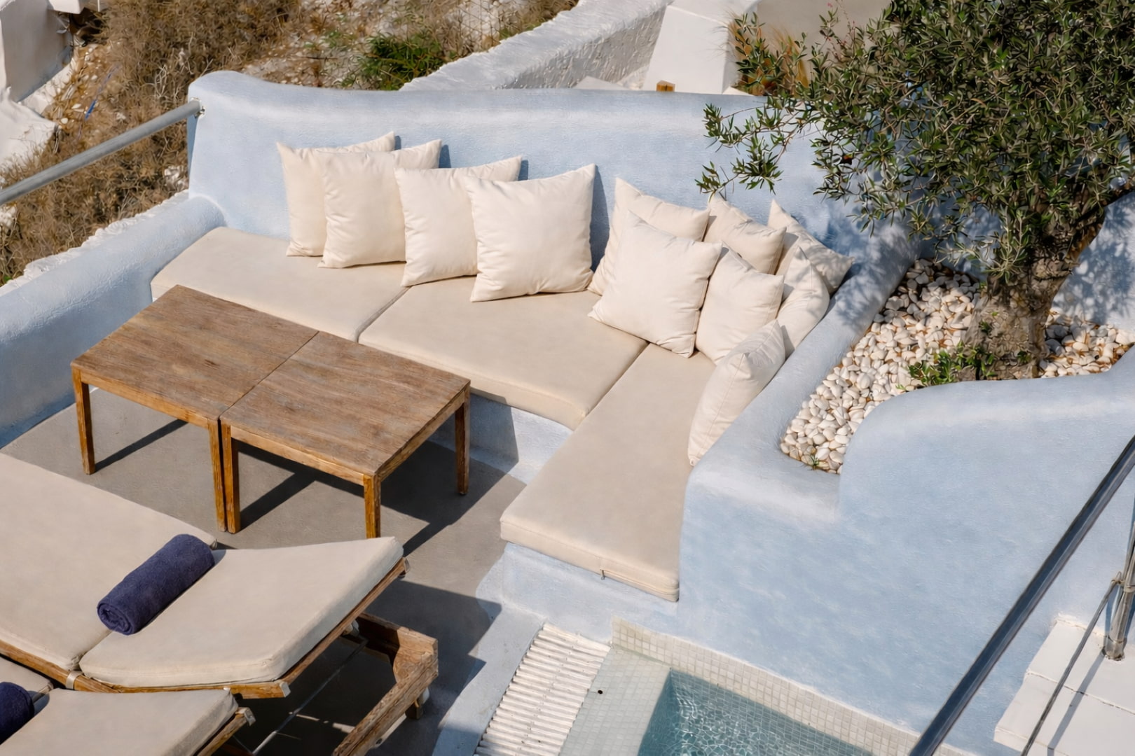 Outdoor lounge seating area by the pool in Santorini suite
